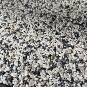 Close-up view of a textured surface covered with small, irregularly shaped gray and beige gravel stones, commonly used in Resin Rock applications.